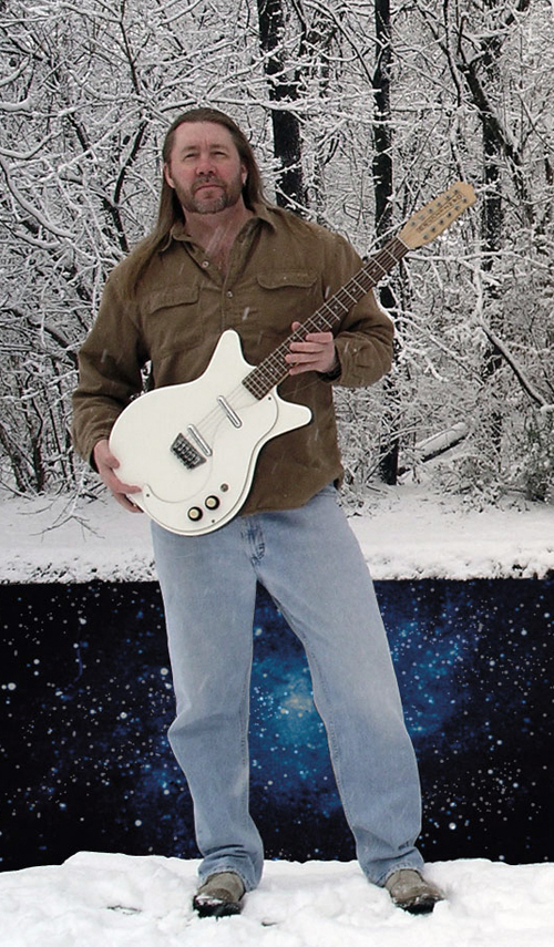 Monty Milne in front of the Space Canal with an electric twelve string guitar